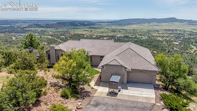 an aerial view of a house with a yard and mountain view in back