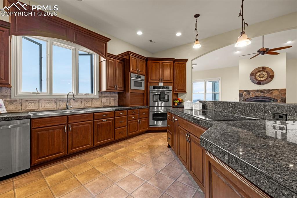 15575 Henry Ride Heights Colorado Springs, CO 80926 - Photo 8 of 46 a large kitchen with stainless steel appliances granite countertop a stove and a sink
