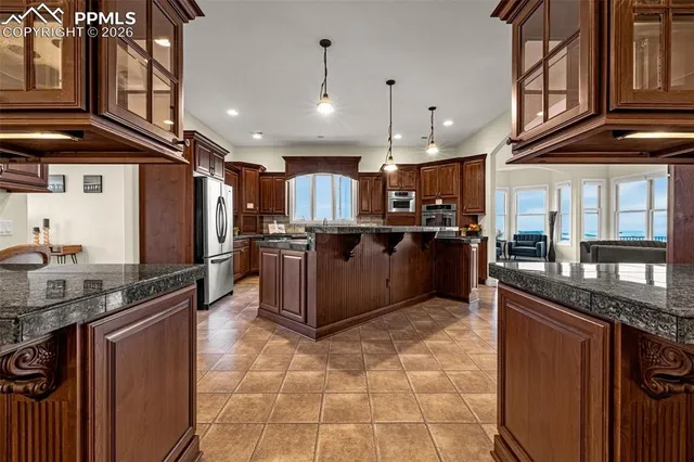 a kitchen with stainless steel appliances granite countertop a sink and a refrigerator