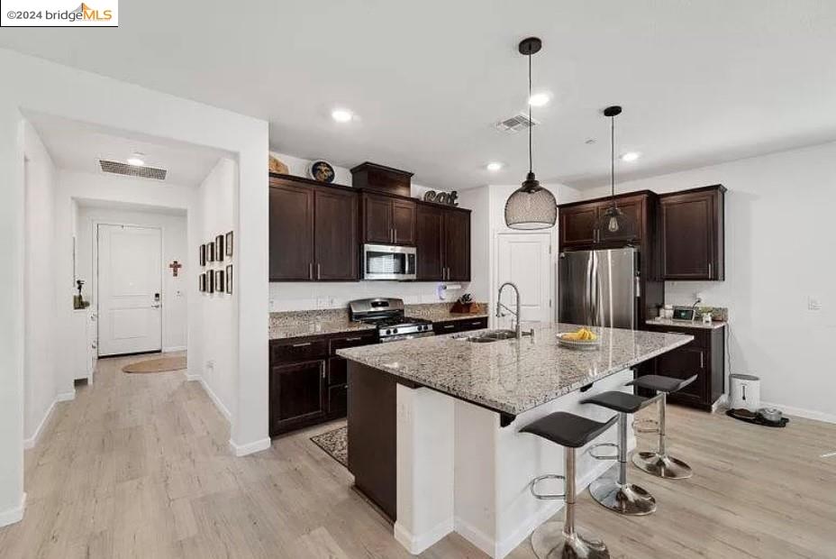 1749 Botticelli Way Lodi, CA 95242 - Photo 8 of 24 a kitchen with stainless steel appliances granite countertop a stove a refrigerator a sink a oven with a dining table and chairs