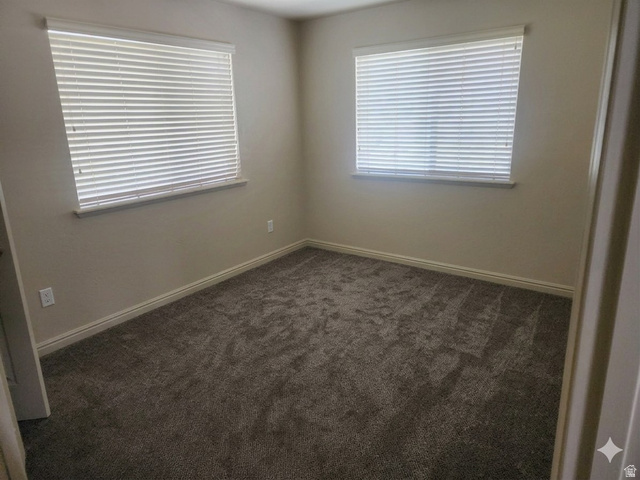 2525 West 450 South, Unit 8 Springville, UT 84663 - Photo 13 of 22 Neutral painted walls featuring two windows with horizontal blinds and gray carpet flooring