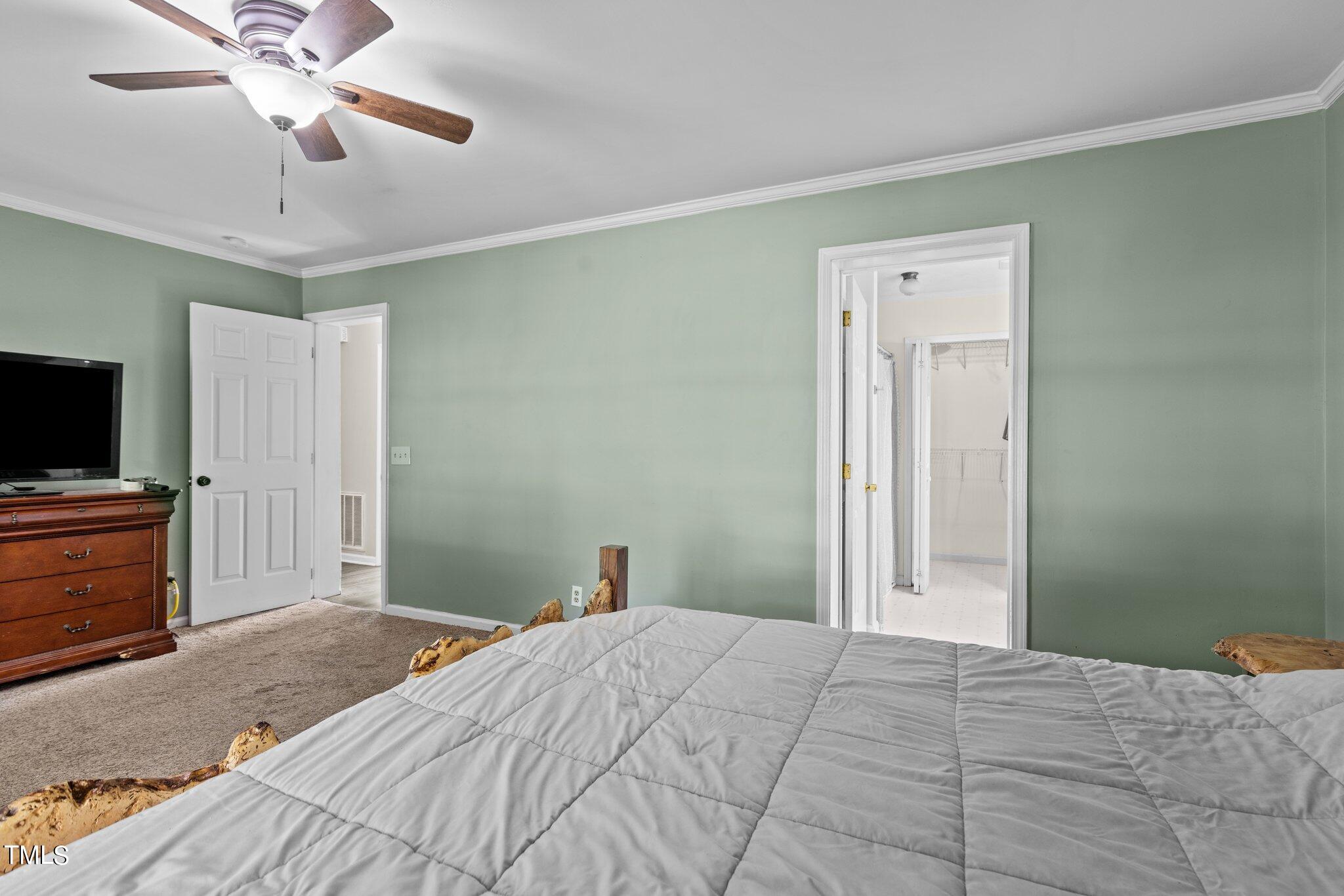 5321 Holland Church Road Raleigh, NC 27603 - Photo 21 of 43 a bedroom with a bed and a flat tv screen on dresser