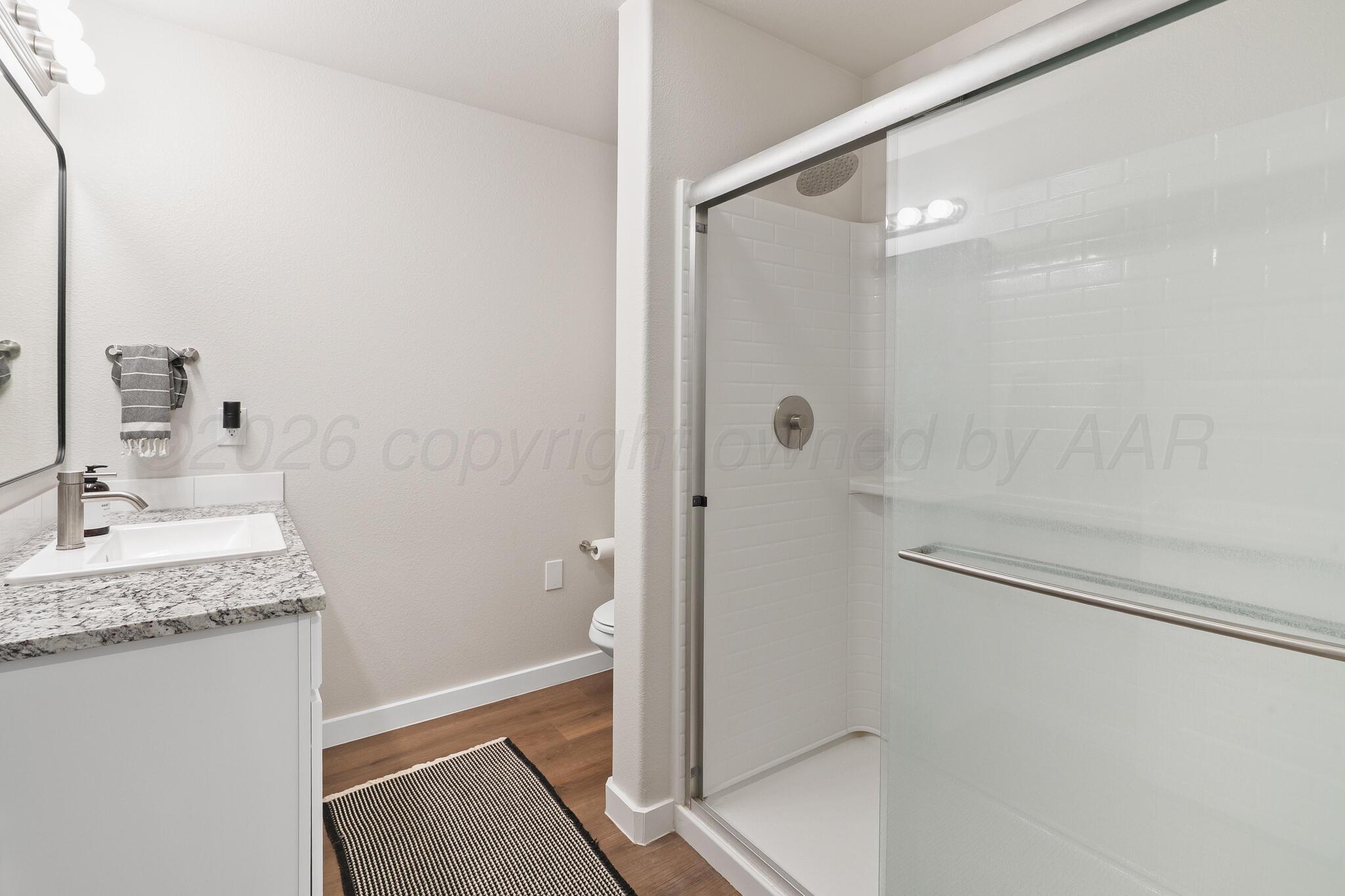 7500 Castleman Road Amarillo, TX 79119 - Photo 12 of 20 a bathroom with a granite countertop sink mirror and shower