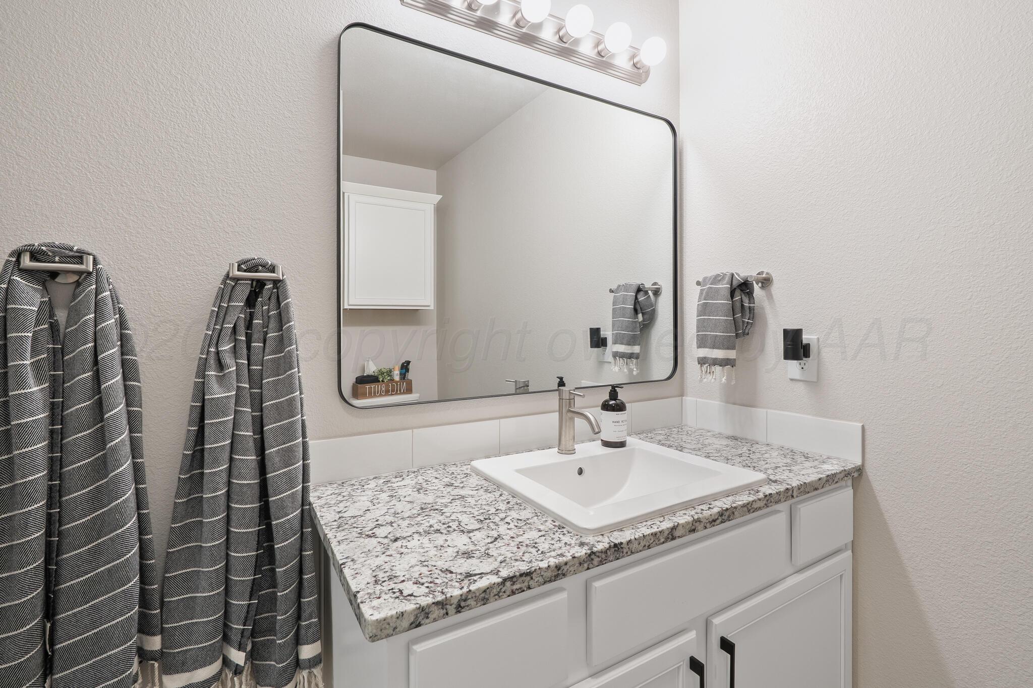 7500 Castleman Road Amarillo, TX 79119 - Photo 13 of 20 a bathroom with a granite countertop sink and a mirror