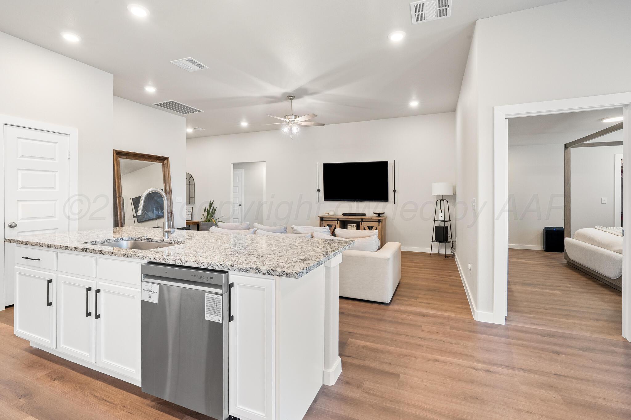 7500 Castleman Road Amarillo, TX 79119 - Photo 4 of 20 a living room with granite countertop furniture a fireplace and a flat screen tv