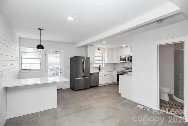 a kitchen with refrigerator and cabinets