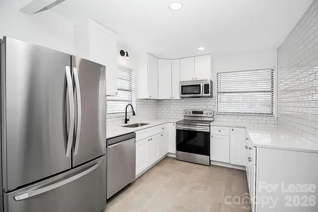 a kitchen with stainless steel appliances granite countertop a refrigerator stove a sink and dishwasher