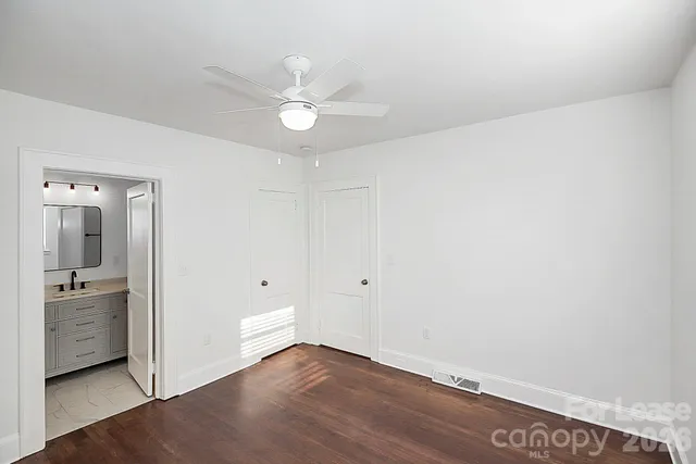 an empty room with a bathroom and a ceiling fan