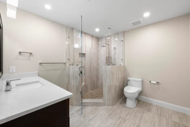 a bathroom with a shower sink vanity and mirror