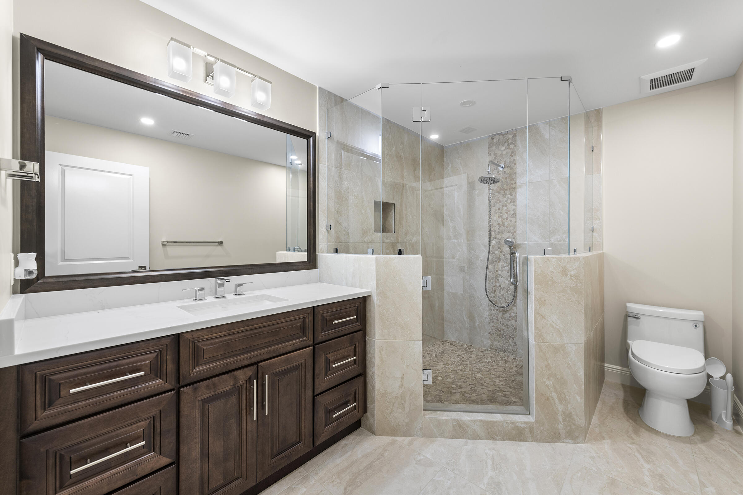 140 Inlet Way, Unit 312 Palm Beach Shores, FL 33404 - Photo 38 of 59 a bathroom with a shower sink vanity and mirror
