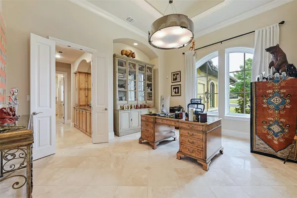 a dining room with furniture large windows and a chandelier