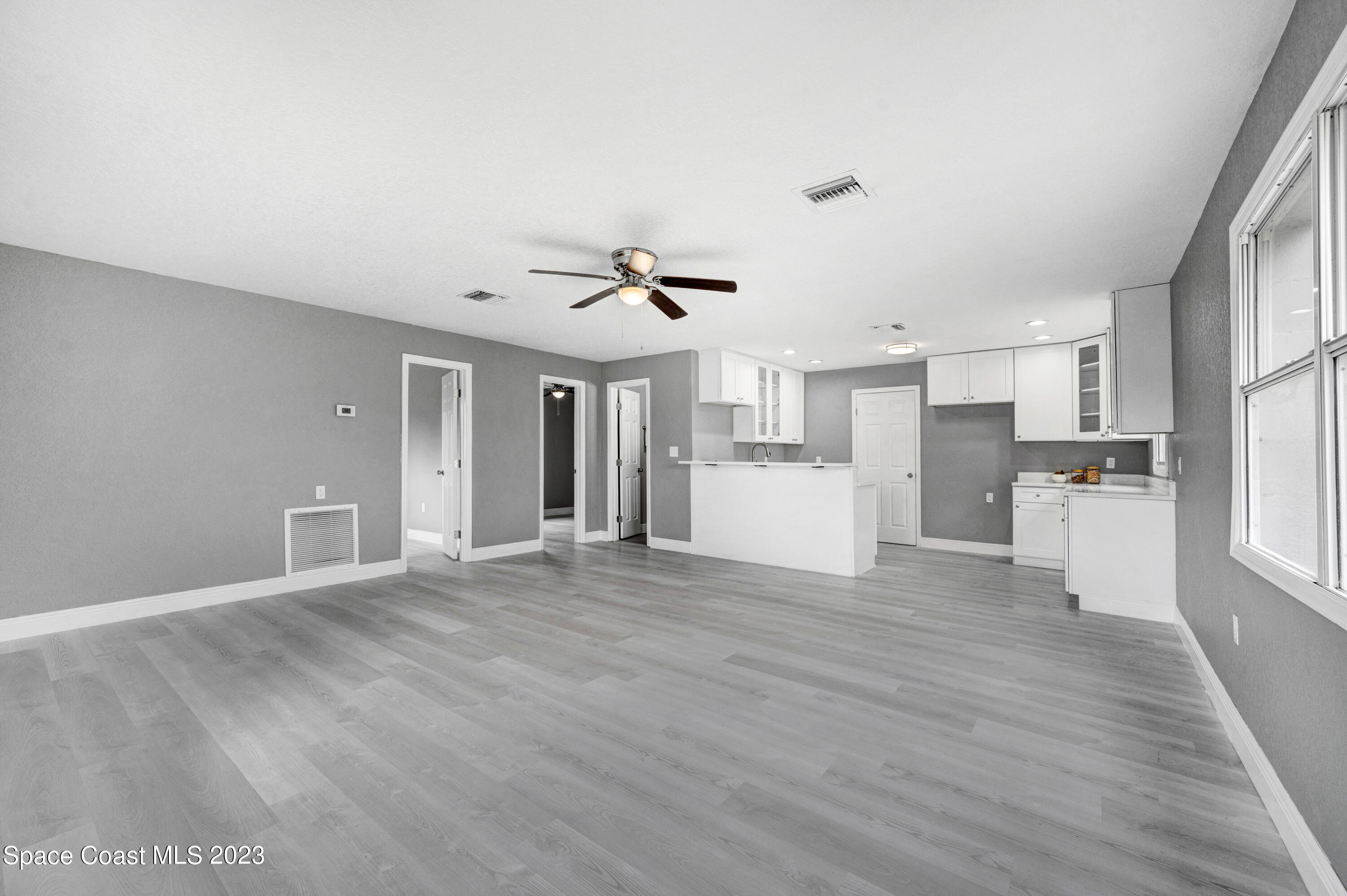 2114 King Richard Road Melbourne, FL 32935 - Photo 8 of 24 a view of a kitchen with wooden floor and electronic appliances