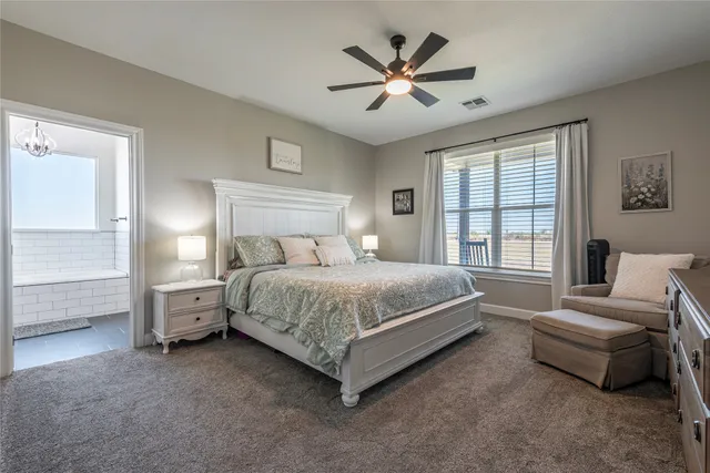 a bedroom with a bed a couch and a large window