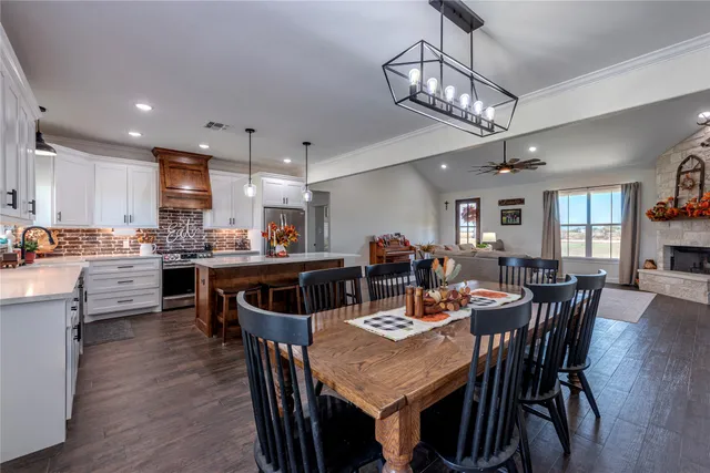 a view of a dining room and livingroom with furniture wooden floor a chandelier