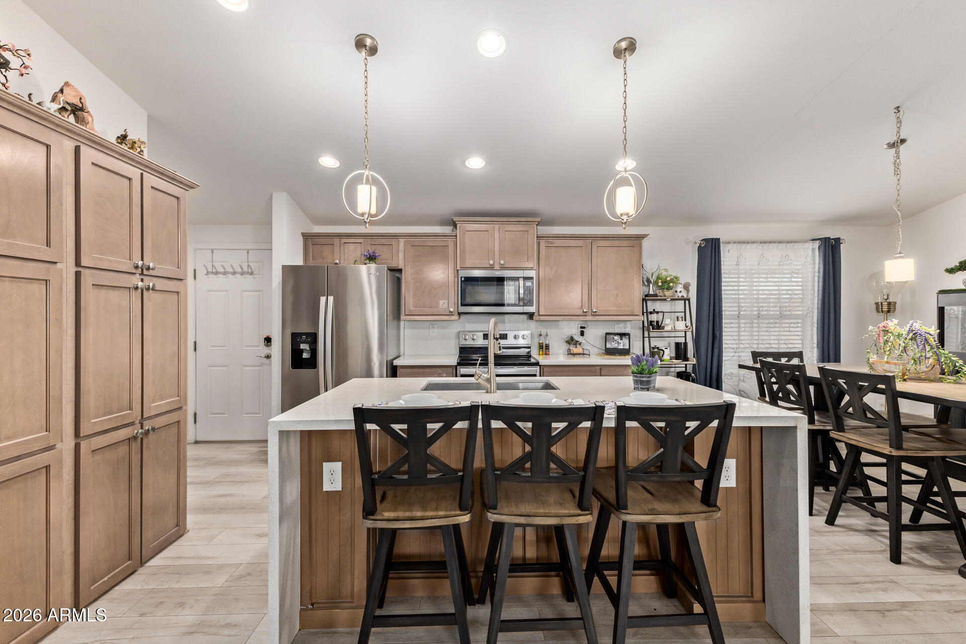 1101 South Ellsworth Road, Unit 153 Mesa, AZ 85208 - Photo 10 of 24 a kitchen with stainless steel appliances a dining table chairs stove and refrigerator