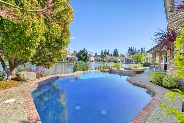 a view of a swimming pool with a patio and a yard