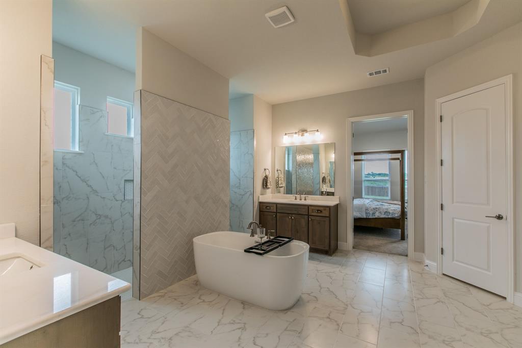 16833 Chapel Road Lorena, TX 76655 - Photo 14 of 40 a bathroom with a tub a sink a mirror and a shower
