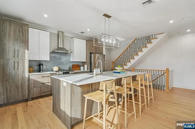 a kitchen with stainless steel appliances granite countertop a table chairs stove and wooden floor