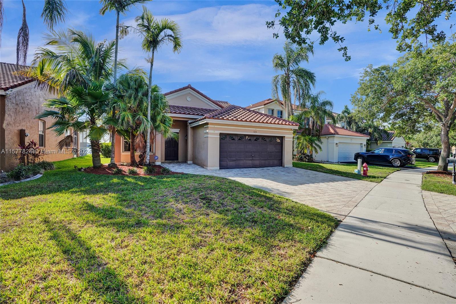 820 Falling Water Road Weston, FL 33326 - Photo 3 of 8 a front view of a house with garden
