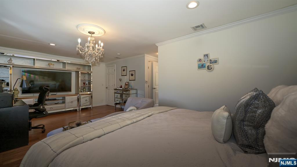 224 Pompton Road Haledon, NJ 07508 - Photo 21 of 34 a bedroom with a bed and a chandelier