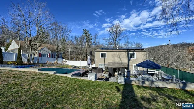 a front view of a house with garden and sitting area