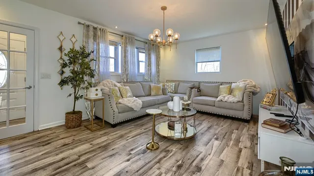 a living room with furniture and a chandelier