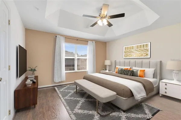 a spacious bedroom with a bed and a flat screen tv