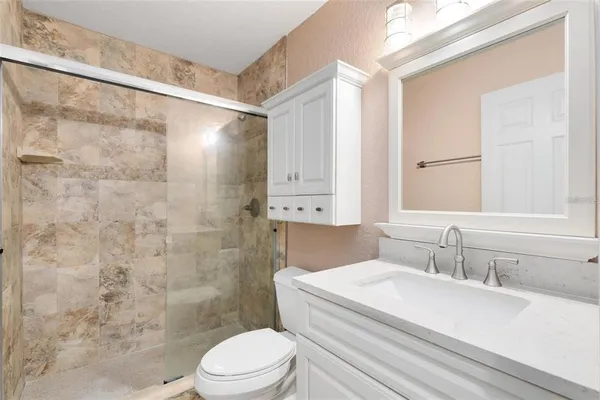 a bathroom with a sink a toilet and shower