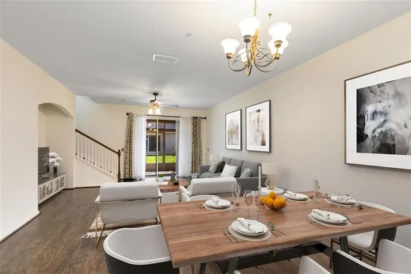a view of a dining room with furniture a chandelier and wooden floor