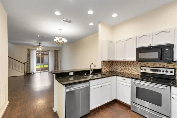 a kitchen with granite countertop a stove and a sink