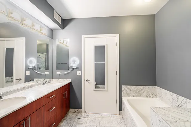 a spacious bathroom with a tub sink and mirror