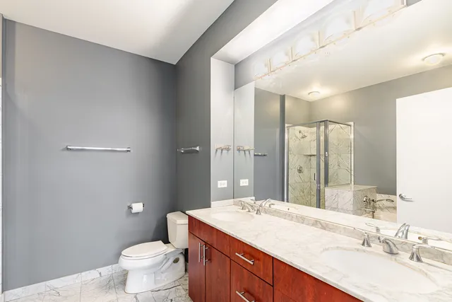a bathroom with a granite countertop sink mirror vanity and toilet