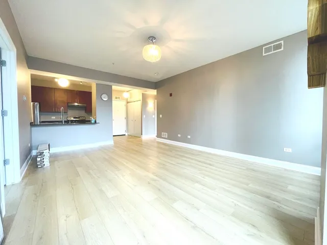 a view of a livingroom with wooden floor and a ceiling fan