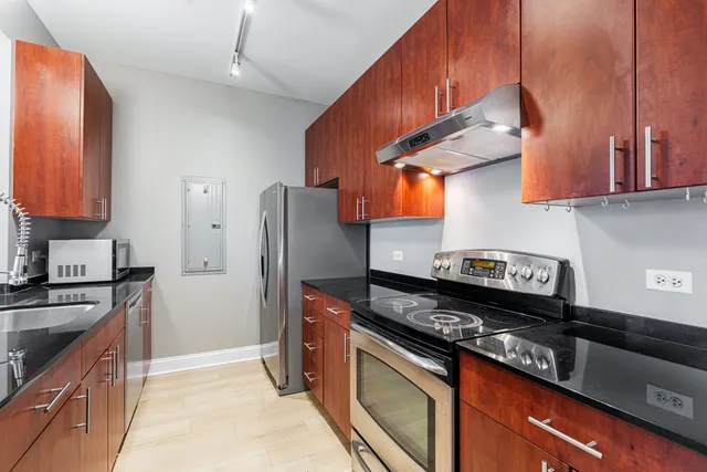 a kitchen with stainless steel appliances granite countertop a stove a refrigerator and a sink