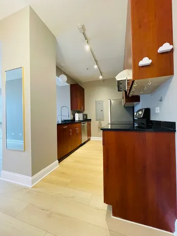 a kitchen with stainless steel appliances granite countertop a refrigerator a sink and a stove