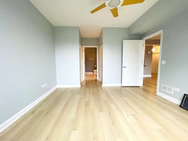 an empty room with wooden floor and bathroom