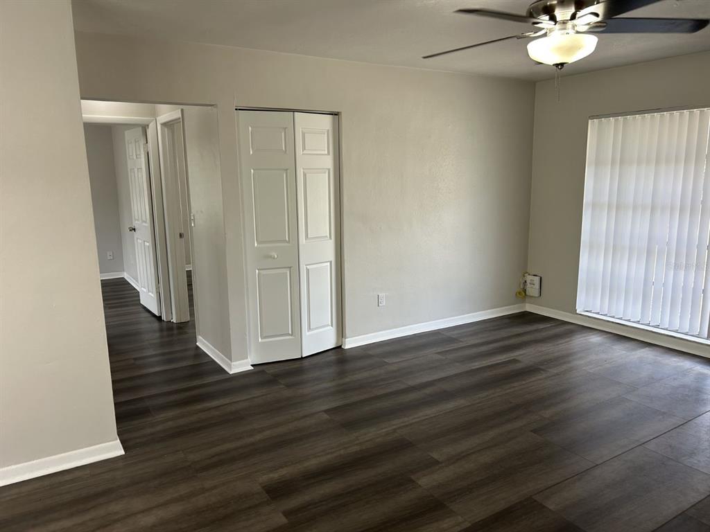 1241 Pilgrim Road Spring Hill, FL 34606 - Photo 6 of 28 an empty room with wooden floor and windows