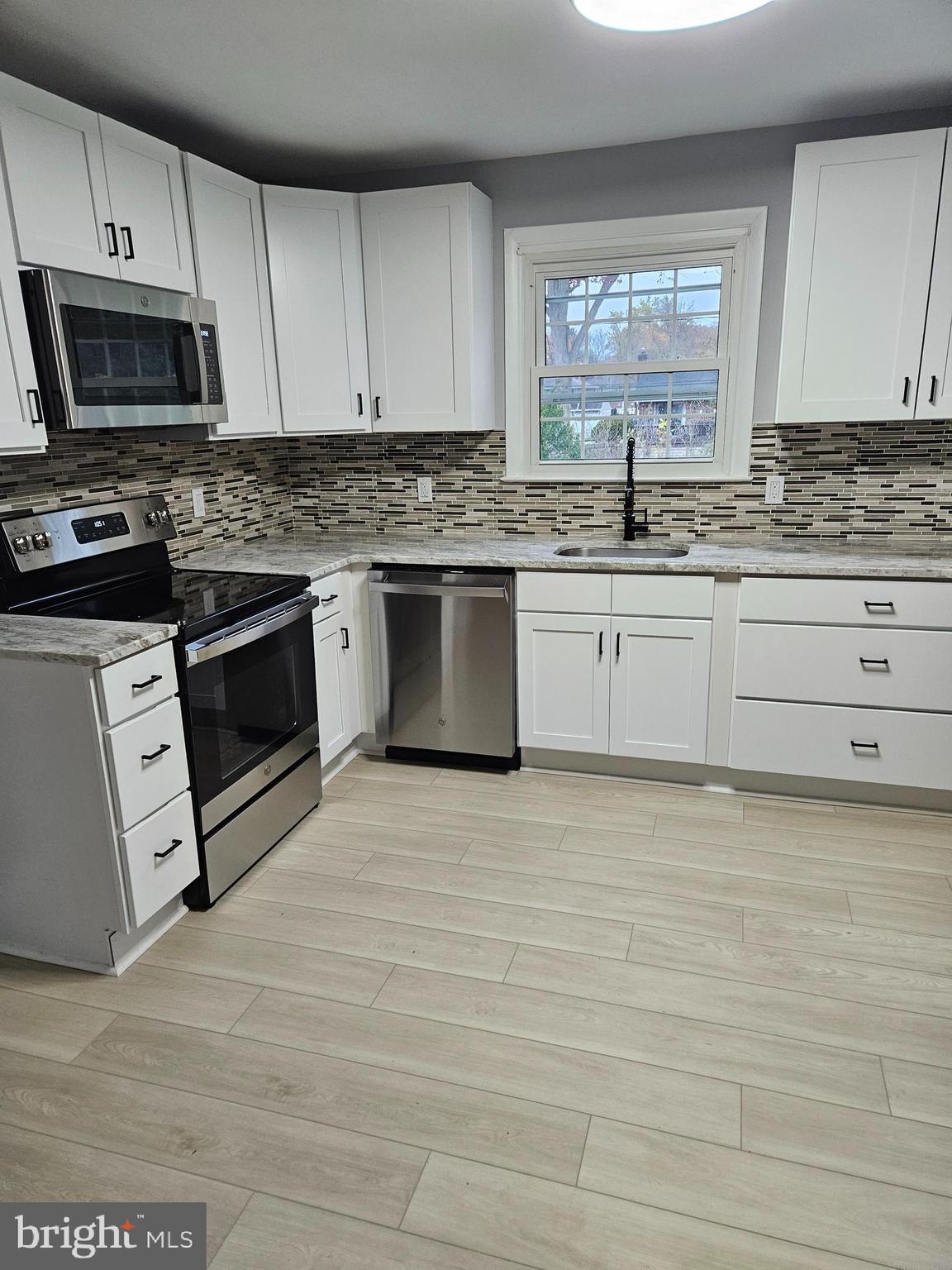 2404 2404-rambler Rambler Road Wilmington, DE 19810 - Photo 3 of 28 a kitchen with granite countertop a stove a sink and a microwave