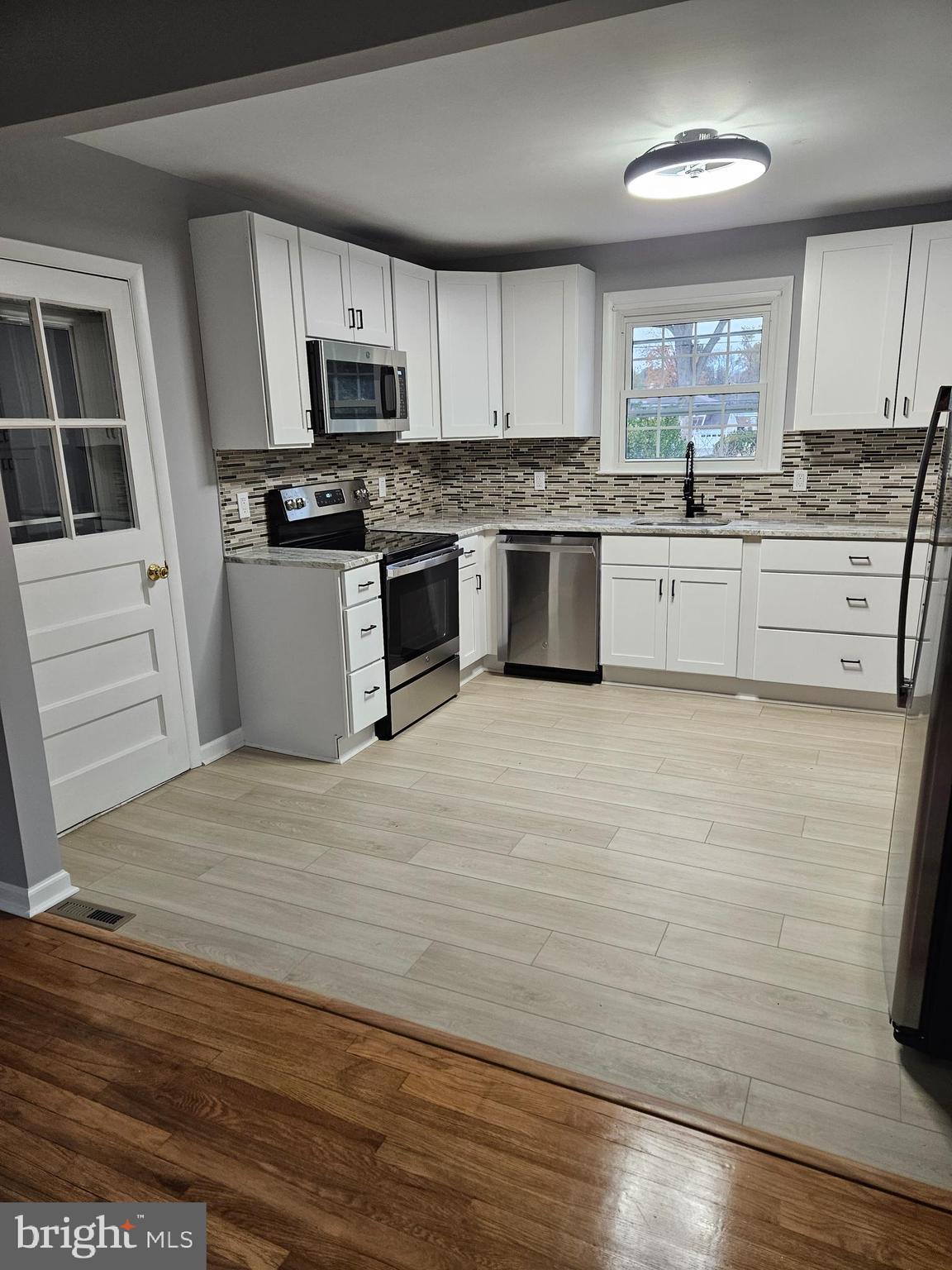2404 2404-rambler Rambler Road Wilmington, DE 19810 - Photo 4 of 28 a kitchen with granite countertop wooden floors stainless steel appliances and sink