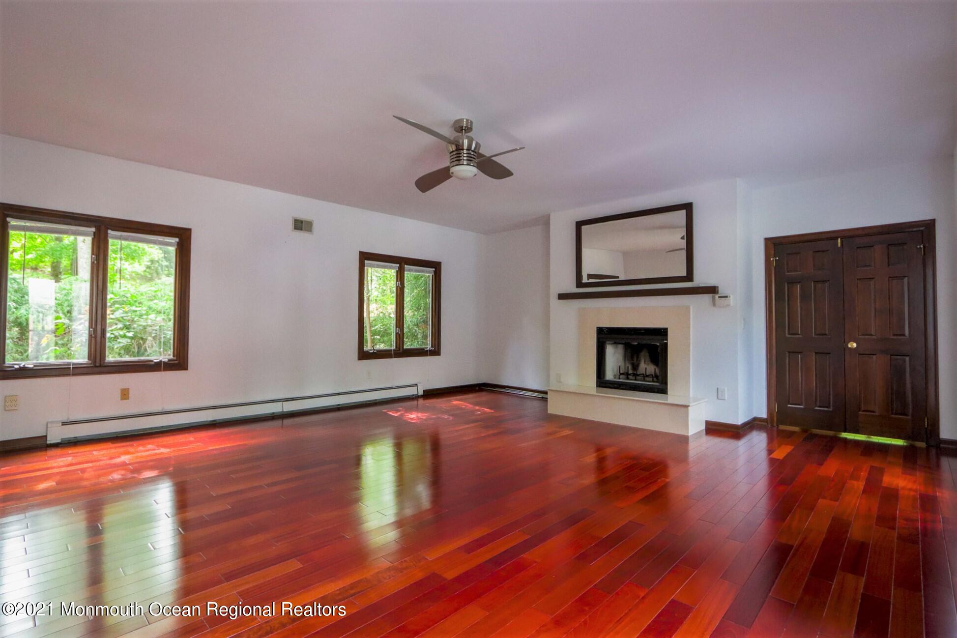 7 Perrine Circle Millstone Township, NJ 08535 - Photo 11 of 27 wooden floor fireplace and windows in an empty room