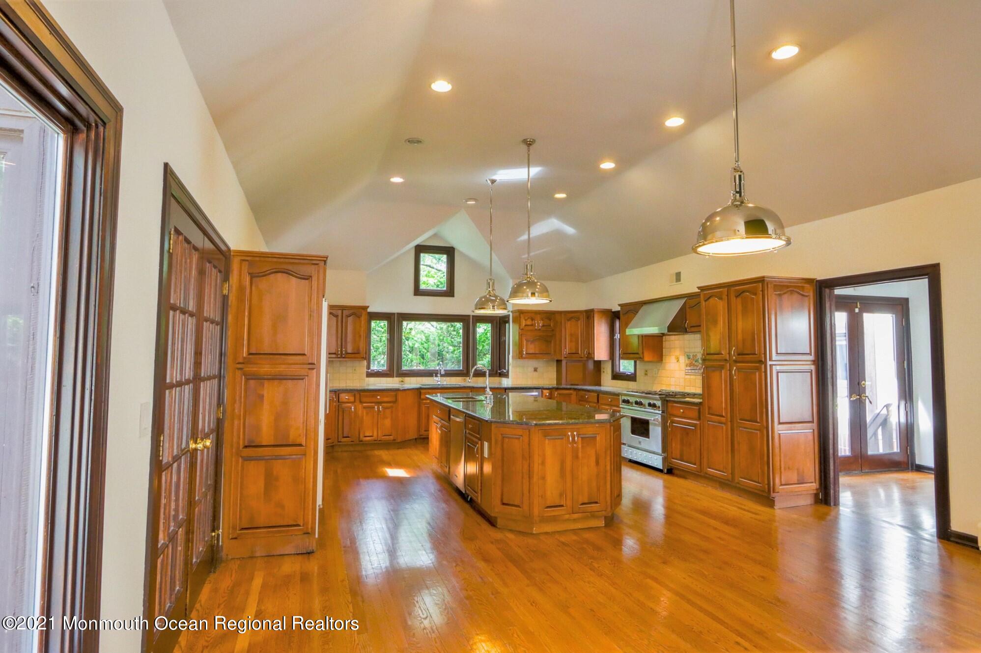 7 Perrine Circle Millstone Township, NJ 08535 - Photo 16 of 27 a open kitchen with stainless steel appliances granite countertop a refrigerator a oven a dining table and chairs with wooden floor