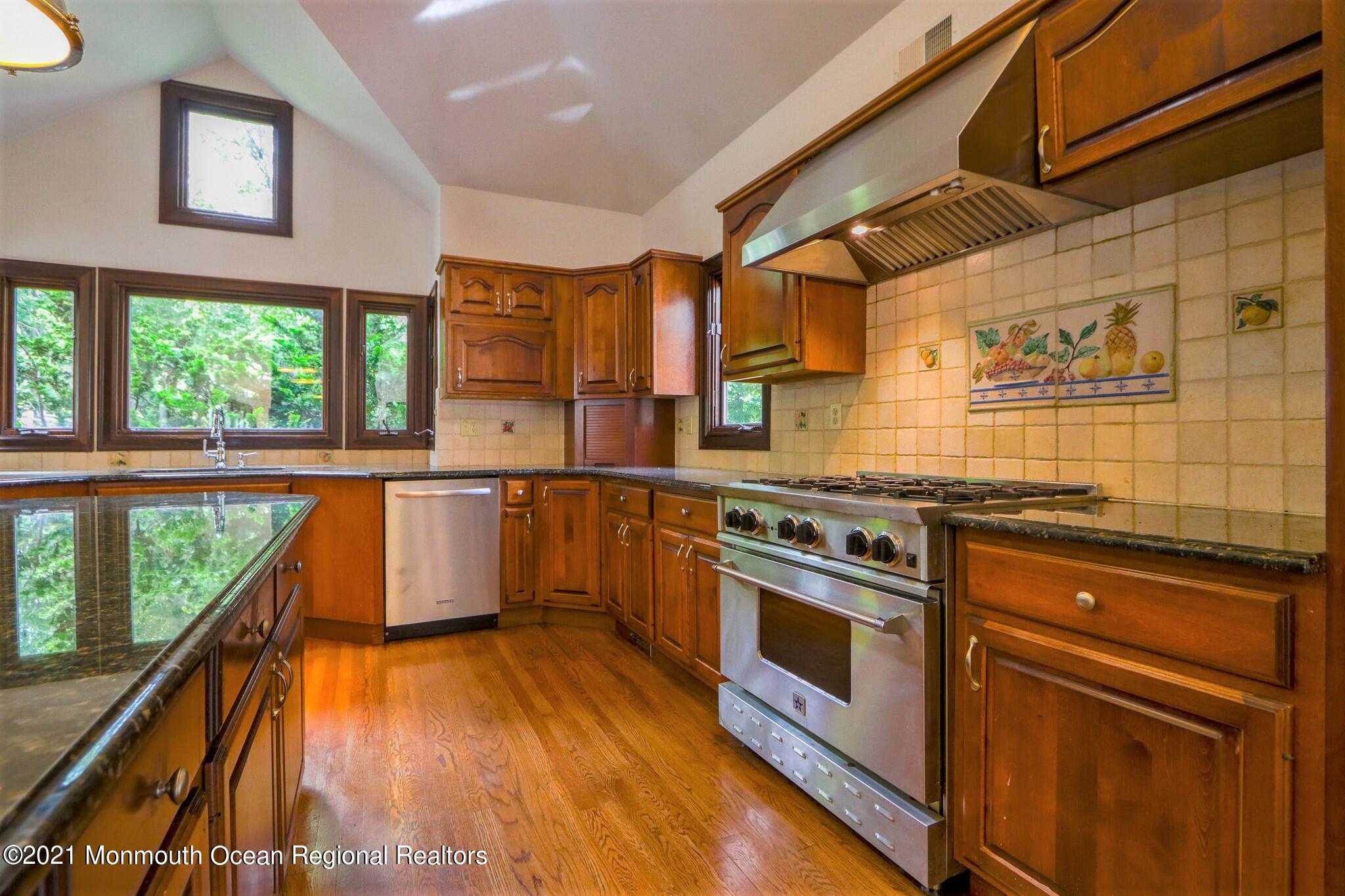7 Perrine Circle Millstone Township, NJ 08535 - Photo 17 of 27 a kitchen with wooden floors and white stainless steel appliances