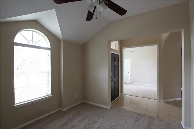 a view of a room with a ceiling fan and a window