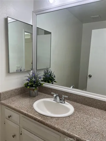 a bathroom with a granite countertop sink and a mirror