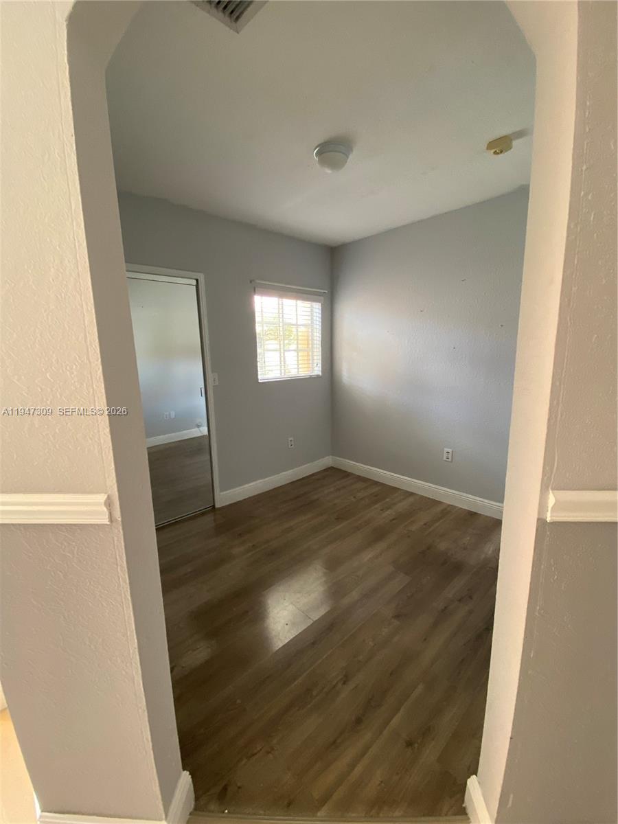 3503 West 76th Street, Unit 4 Hialeah, FL 33018 - Photo 11 of 31 an empty room with wooden floor and windows