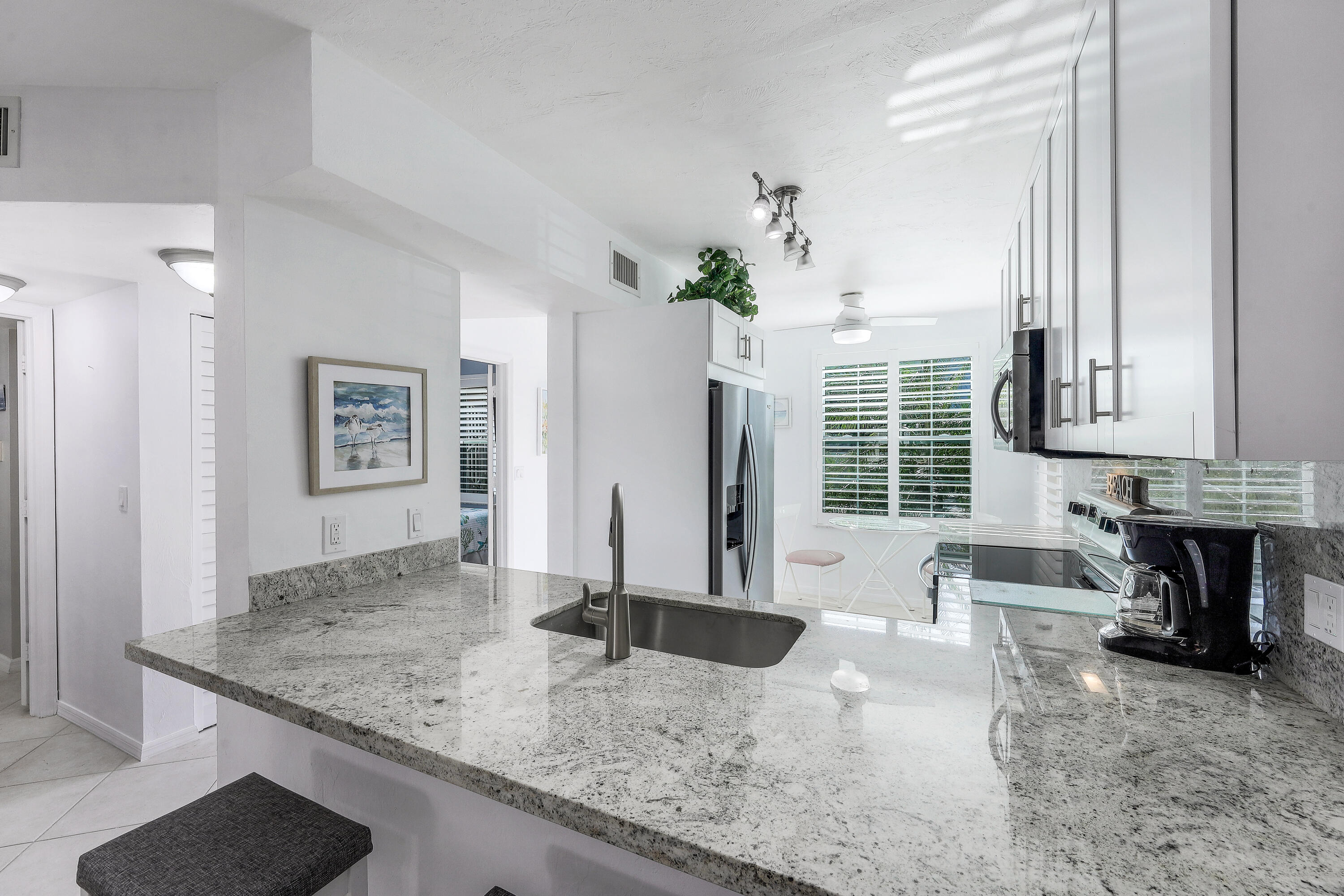 960 Huron Street, Unit 106 Marco Island, FL 34145 - Photo 12 of 39 a view of a kitchen with granite countertop a sink and a stove