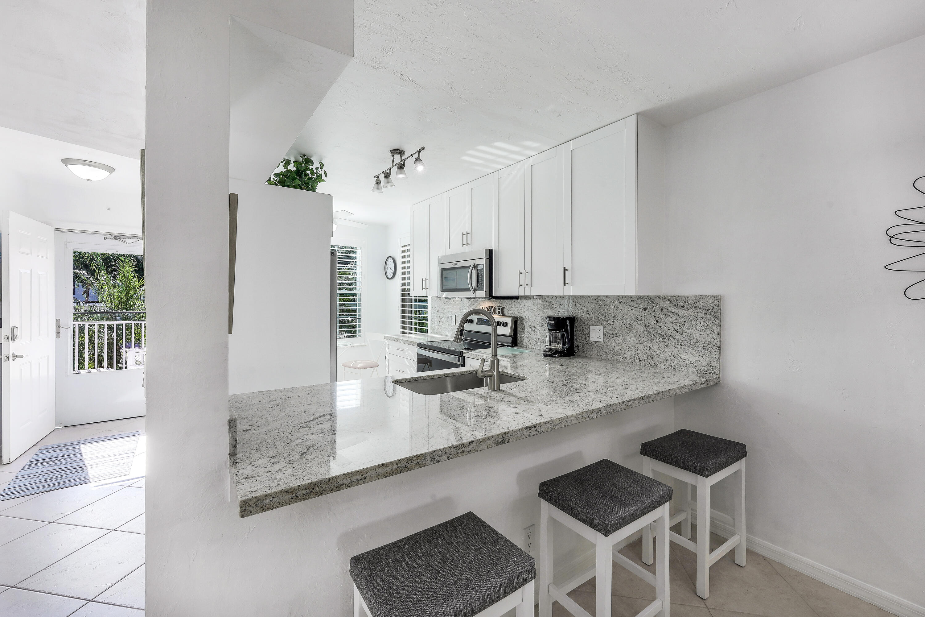 960 Huron Street, Unit 106 Marco Island, FL 34145 - Photo 9 of 39 a kitchen with stainless steel appliances granite countertop a sink and refrigerator