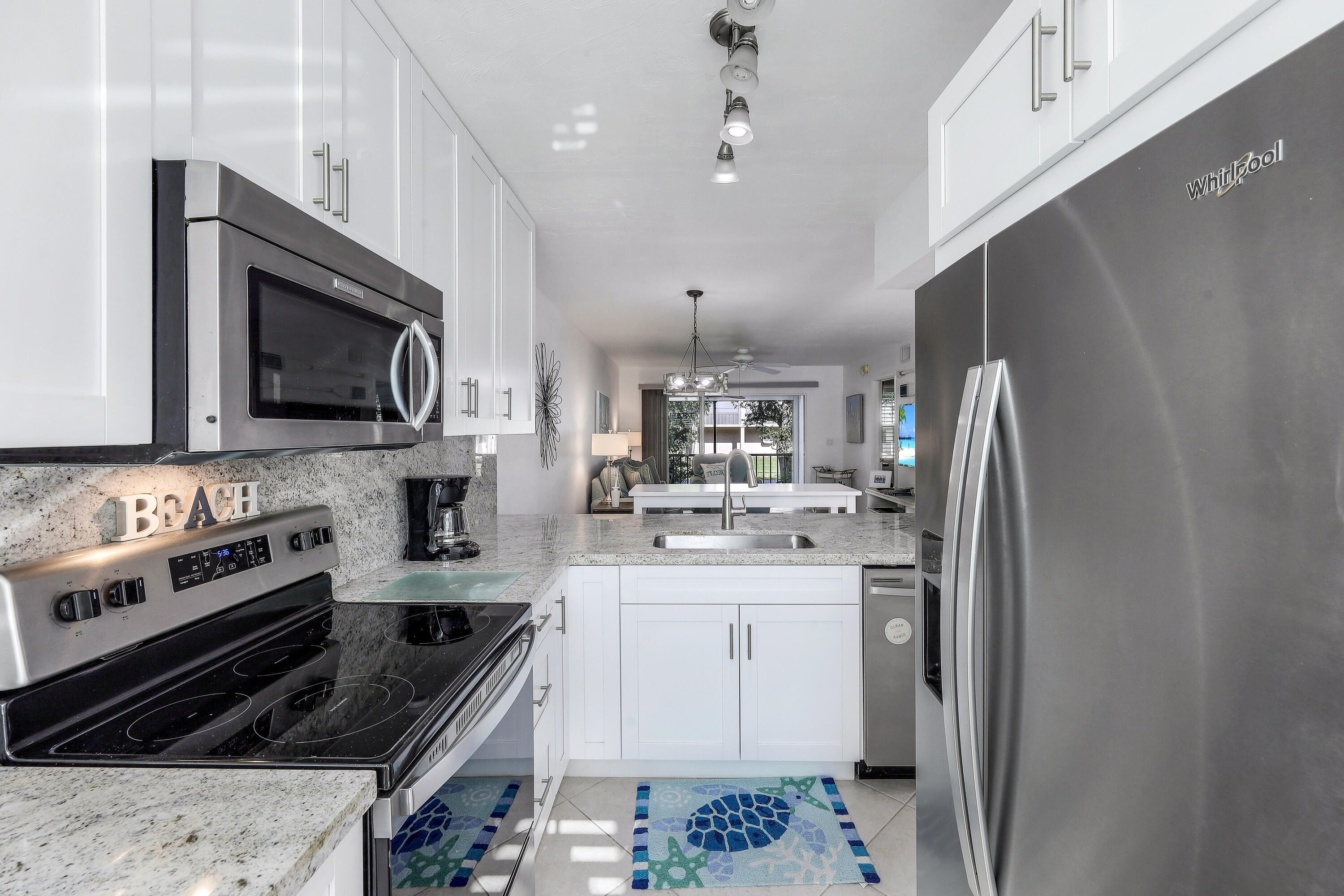 960 Huron Street, Unit 106 Marco Island, FL 34145 - Photo 10 of 39 a kitchen with stainless steel appliances a stove a sink a microwave and cabinets
