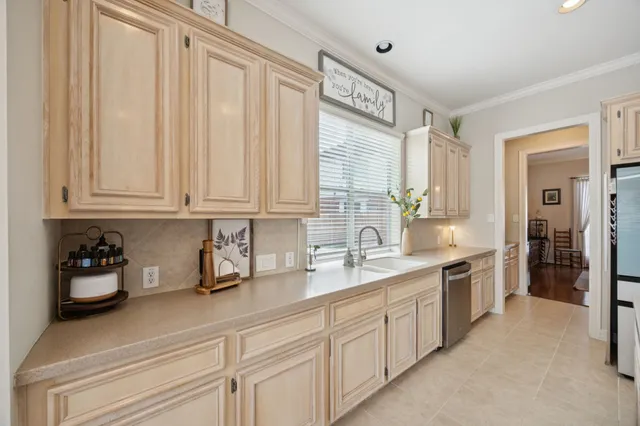 a kitchen with white cabinets and sink