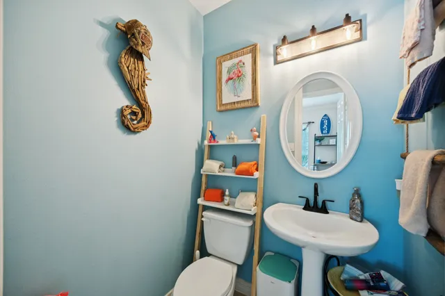 a bathroom with a toilet a sink and a mirror